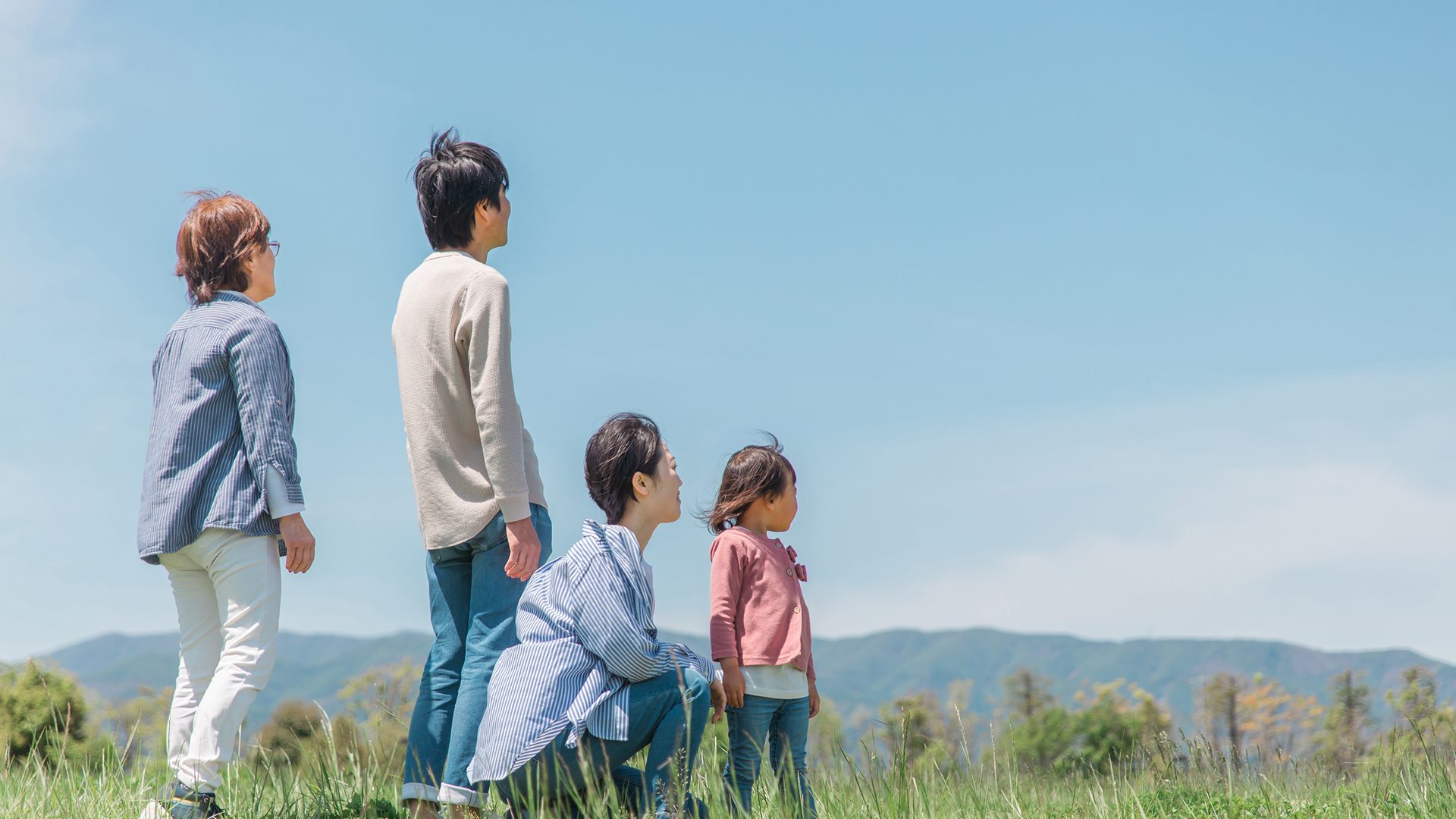草原で遠くを眺めるご家族